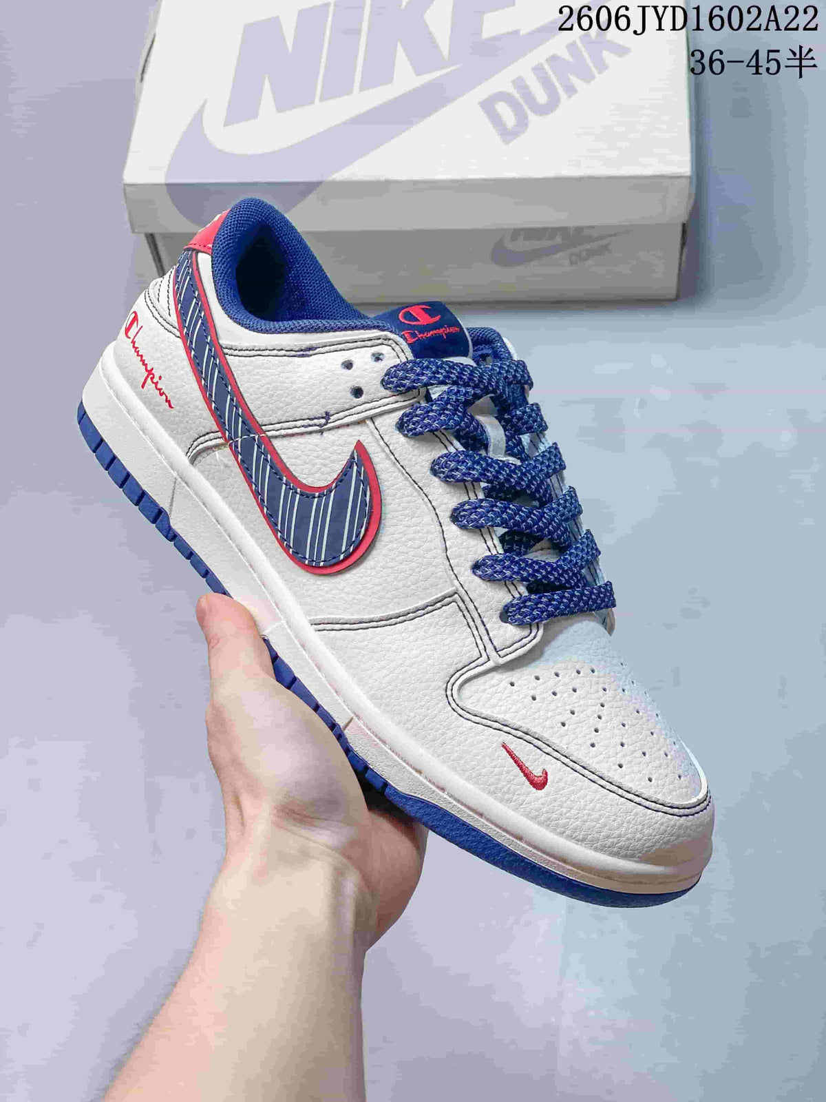 White low-top sneaker with blue striped side accent, red details and blue laces