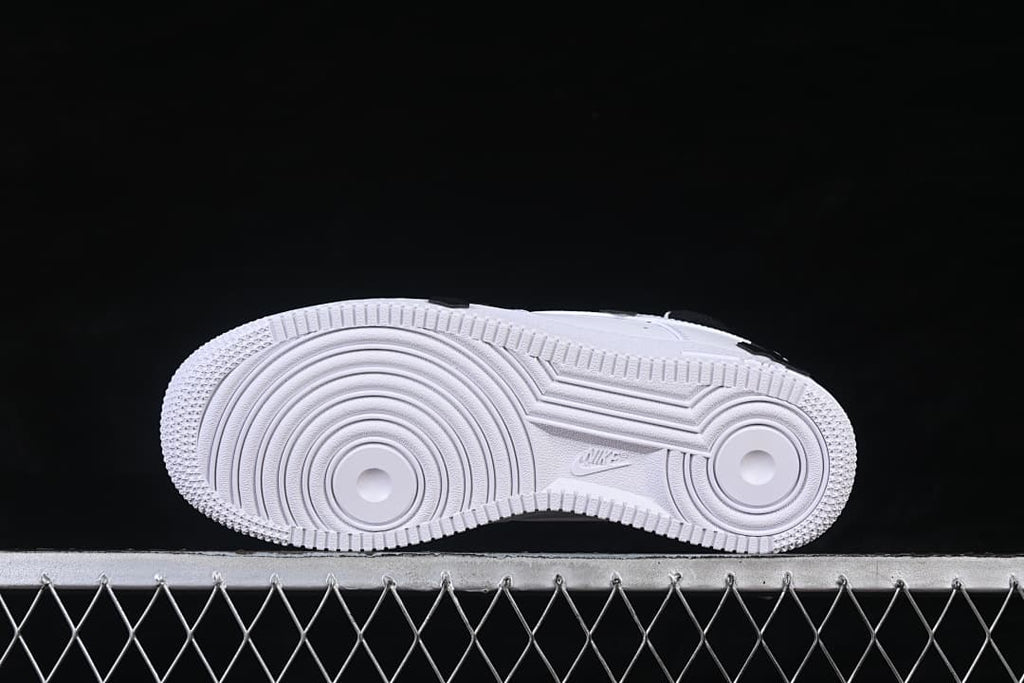 Underside view of the white sneaker outsole with circular tread patterns.
