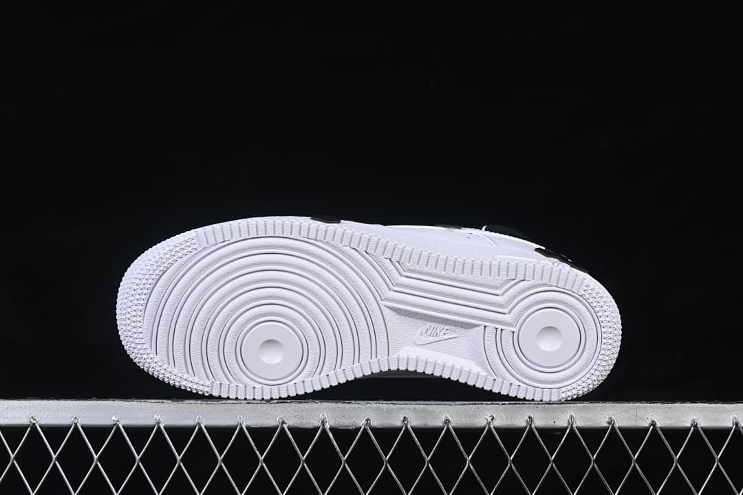 Underside view of the white sneaker outsole with circular tread patterns.