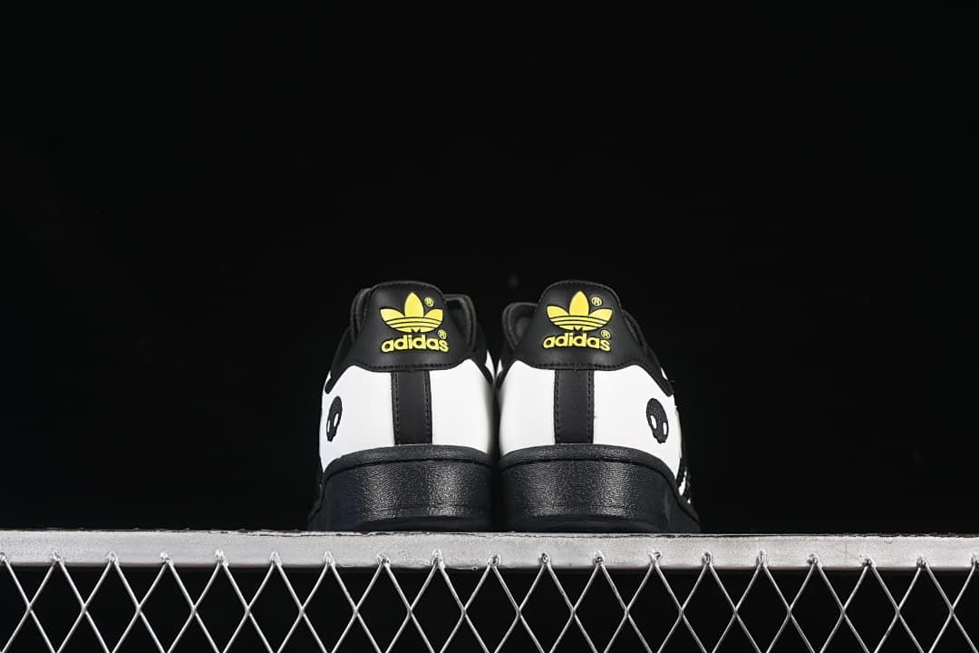 Rear view of both shoes with black soles and yellow heel logos