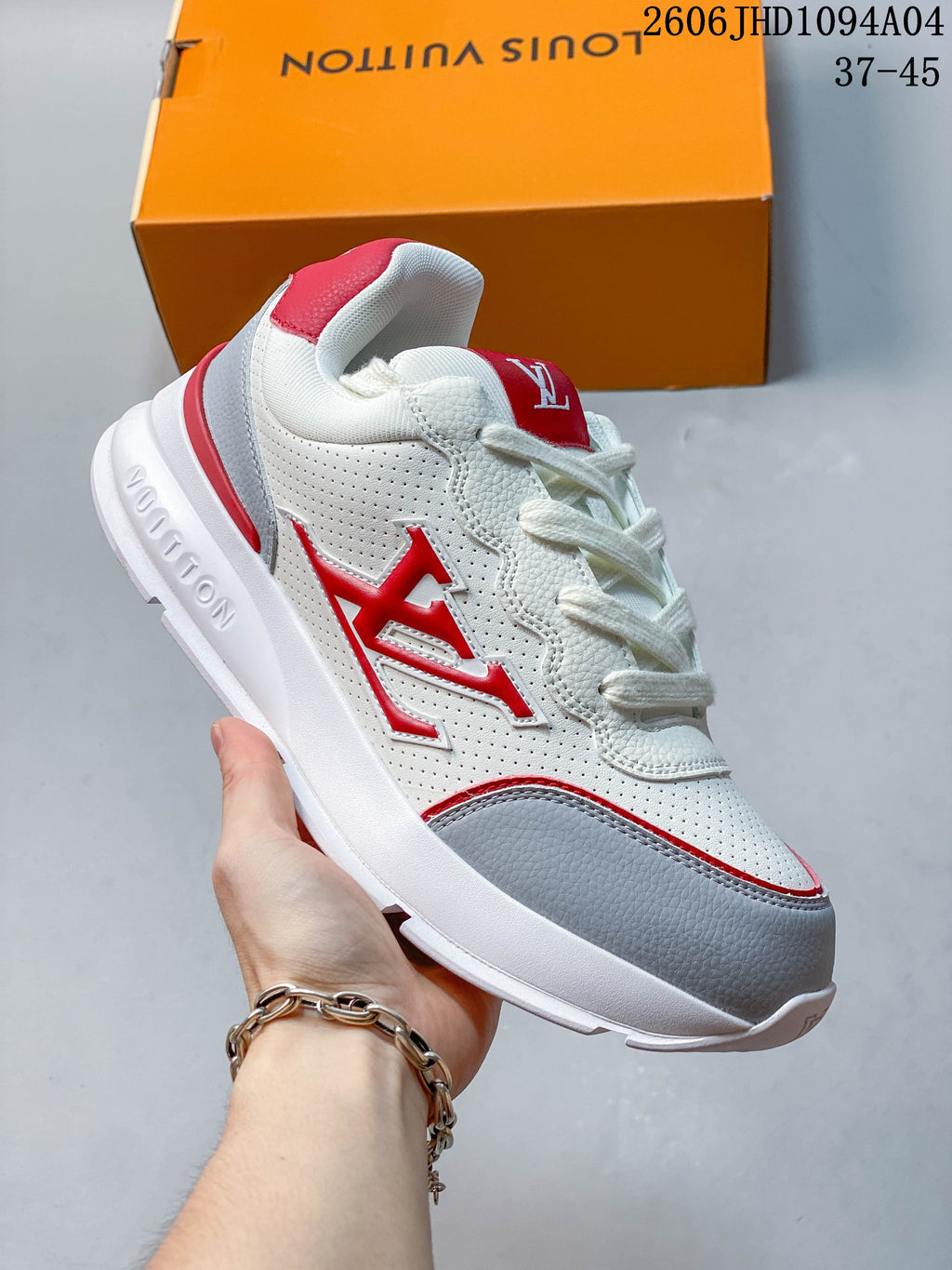 White low-top Louis Vuitton Trainer sneaker with red accents and a gray toe panel