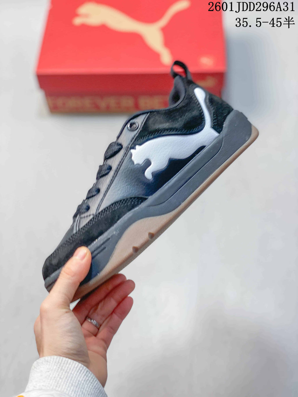 Side view of a dark sneaker with white cat-shaped side detail and a thick sole