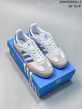 White and blue adidas Samba OG low-top sneakers with a gum-colored outsole, shown on a blue shoe box.