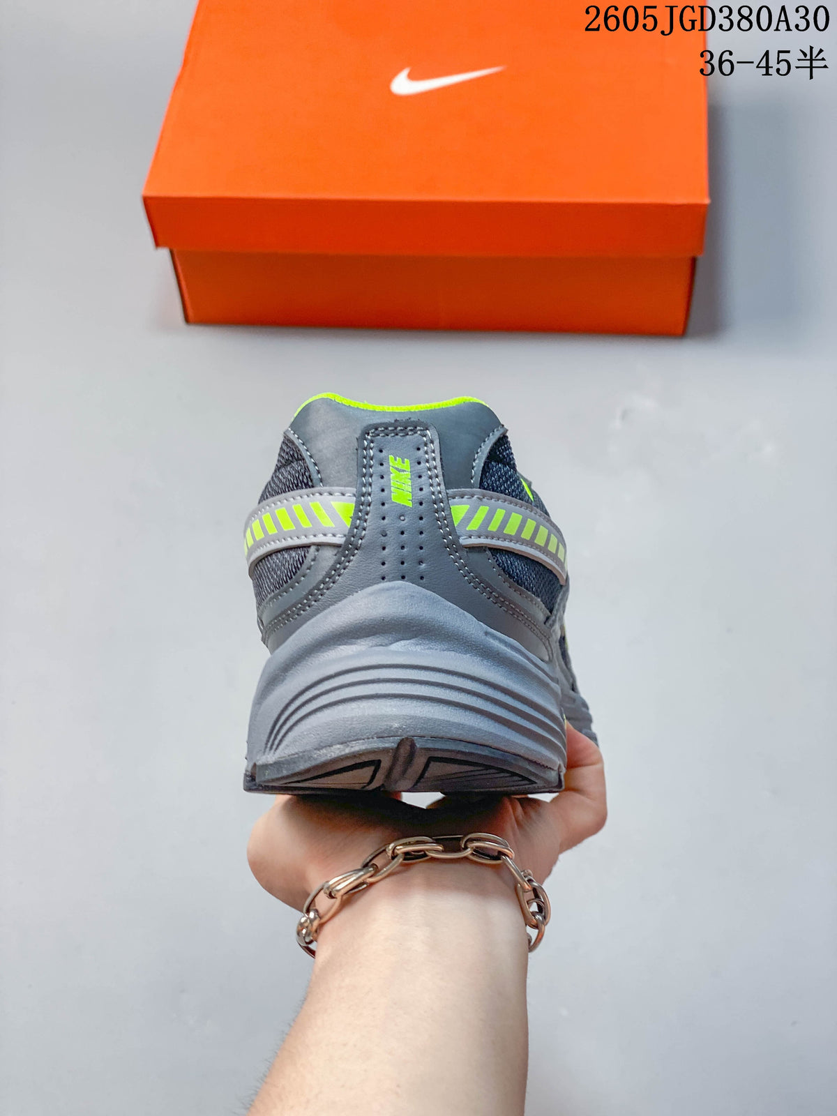 Rear view of a gray sneaker with a volt-accented heel band and padded-looking collar.
