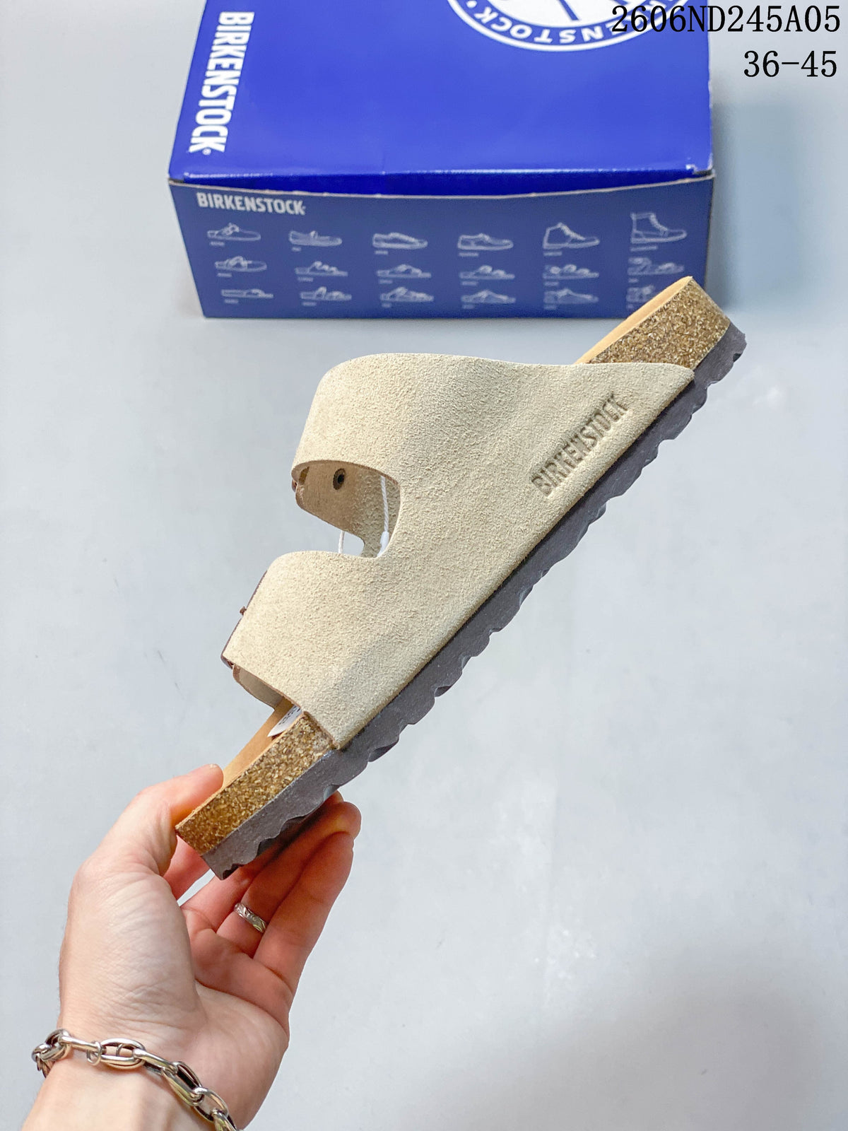 Side profile of a beige two-strap sandal with a contoured footbed.