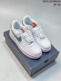 Pair of white Nike Air Force 1 Shadow sneakers with green side accents, red patterned tongue labels, and gold-tone lace hardware.