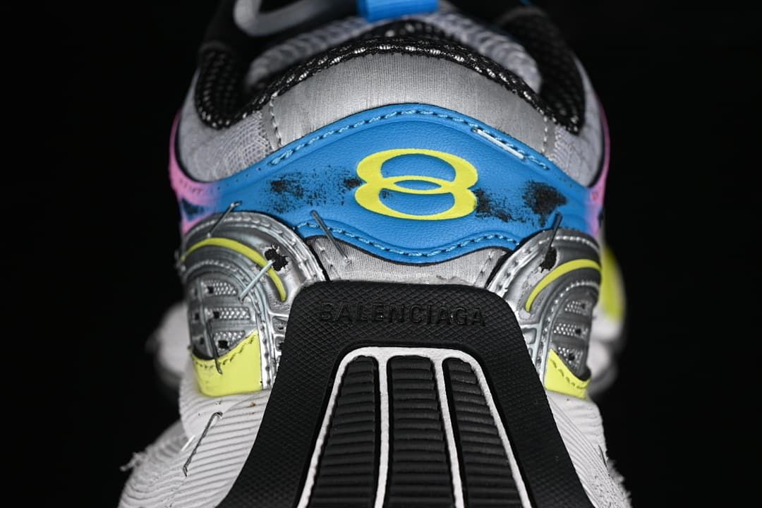 Rear view of the sneaker with blue, yellow, pink, and silver details