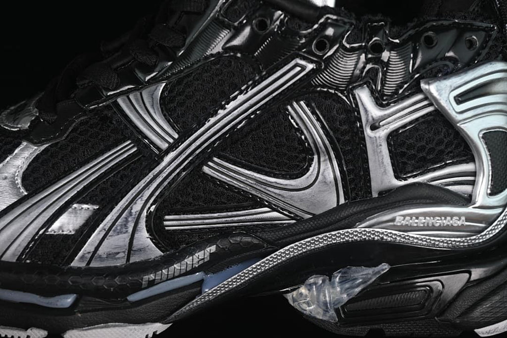 Close-up of the black mesh upper, silver overlays, and sculpted sole.