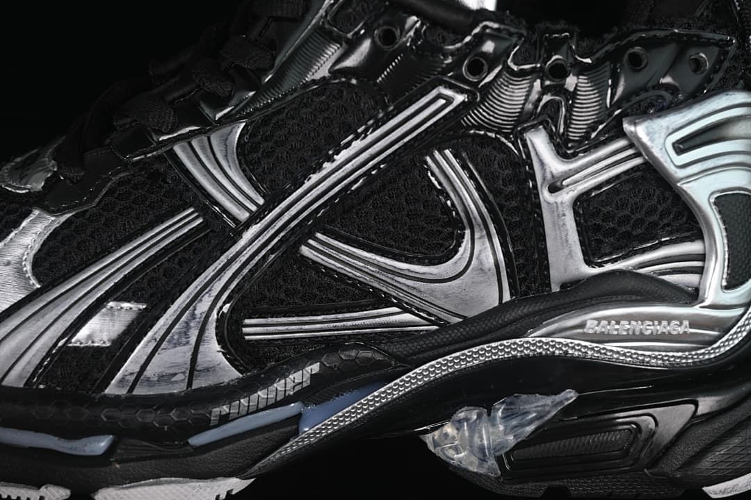 Close-up of the black mesh upper, silver overlays, and sculpted sole.