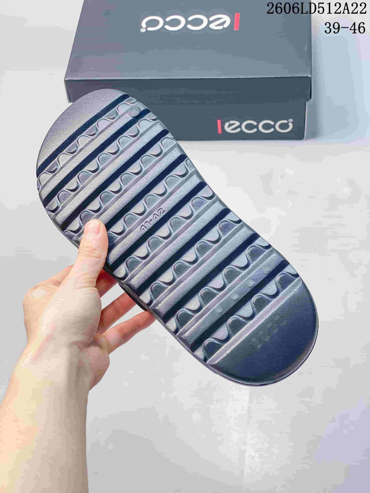 Close-up of the ridged outsole of a dark gray sandal; image displays style code 2606LD512A22 and sizes 39–46.