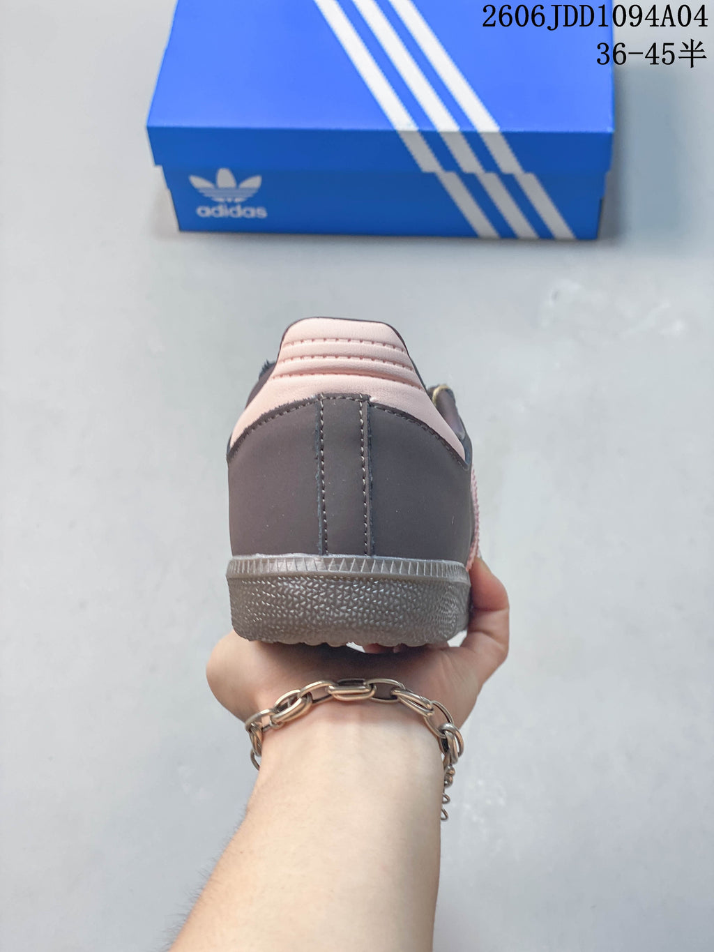 Rear view of the gray-brown sneaker showing its pale pink heel detail