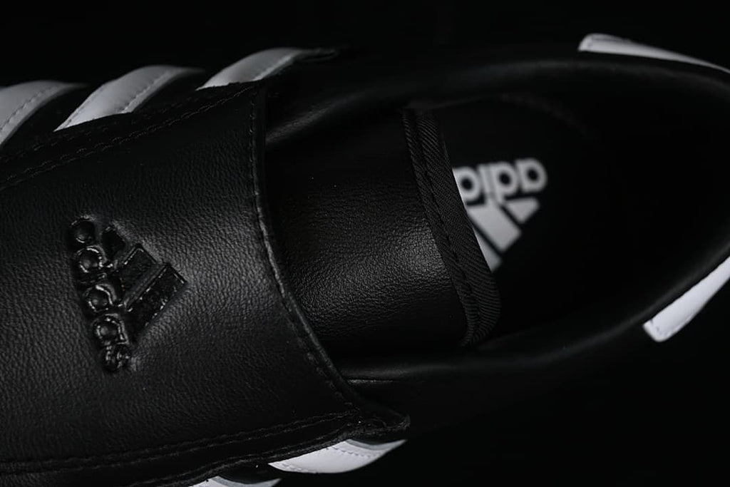 Close-up of the black fold-over strap and interior branding.