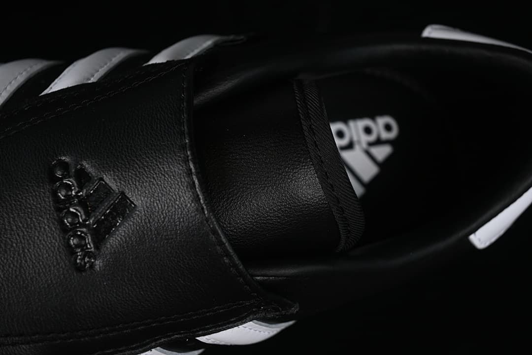 Close-up of the black fold-over strap and interior branding.