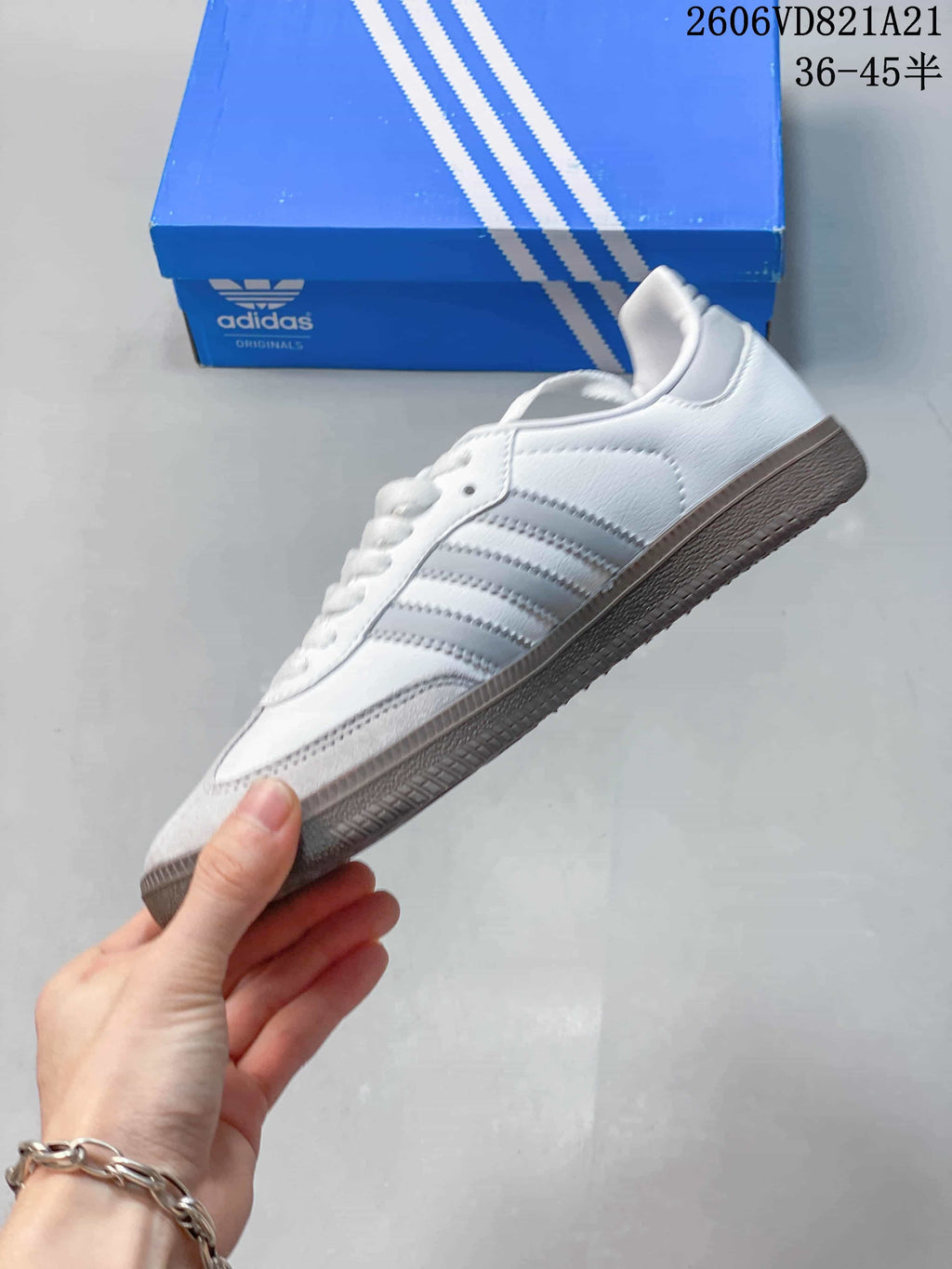 Side profile of a white low-top sneaker with grey stripes and toe overlay