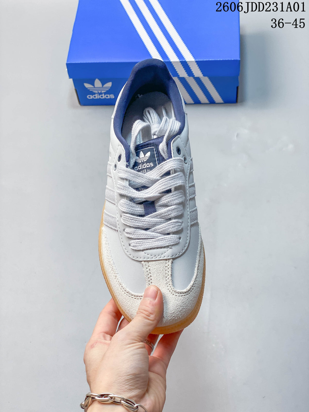 Top view of a lace-up sneaker with a white upper, gray detailing, and navy lining.