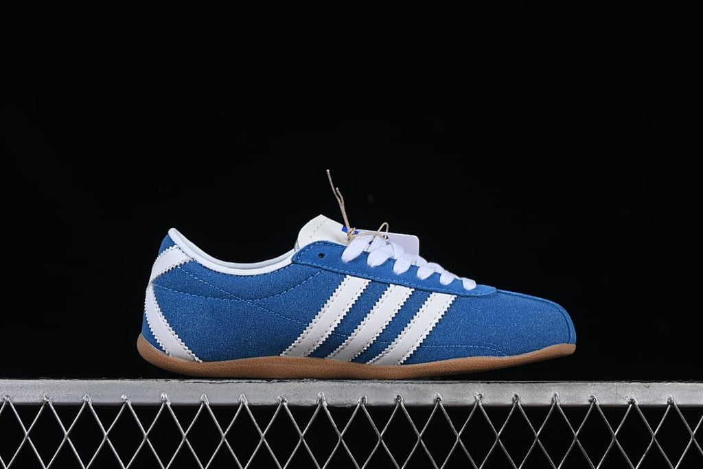 Side profile highlighting the blue upper, white stripes and gum outsole