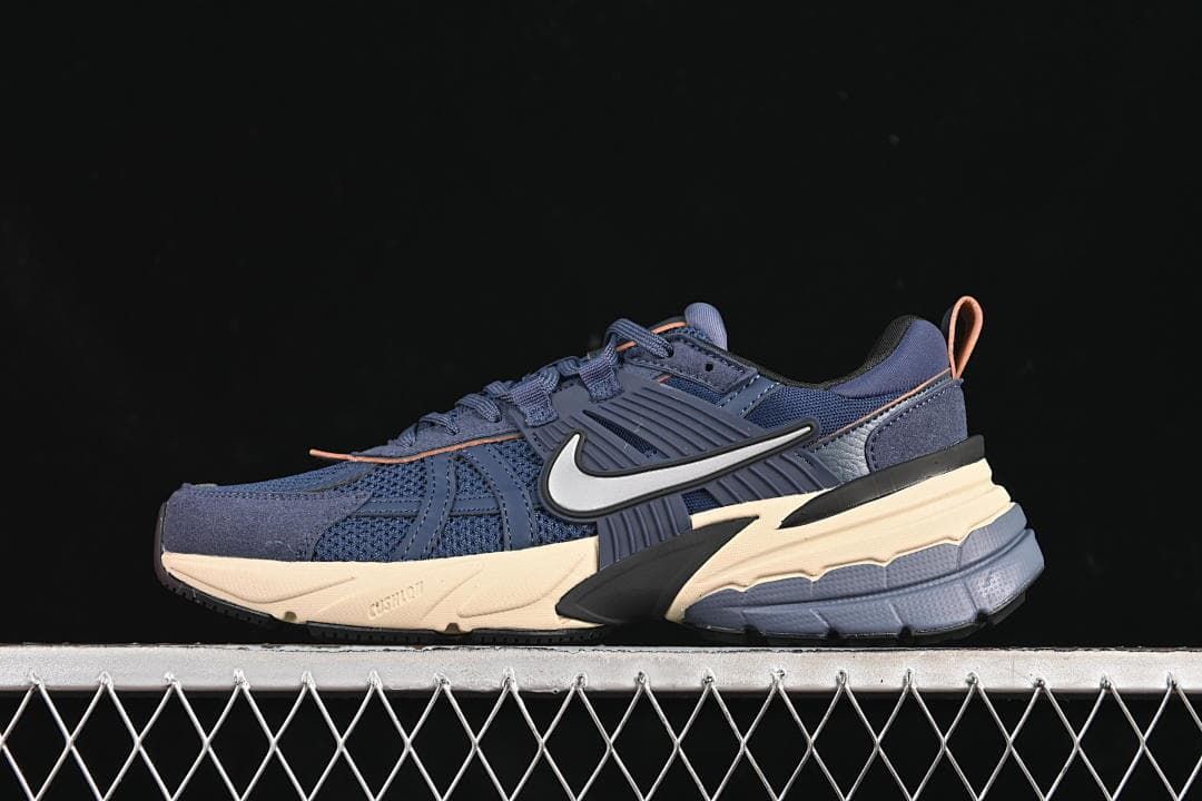 Side view of a navy Nike V2K Run sneaker with cream-toned sole accents
