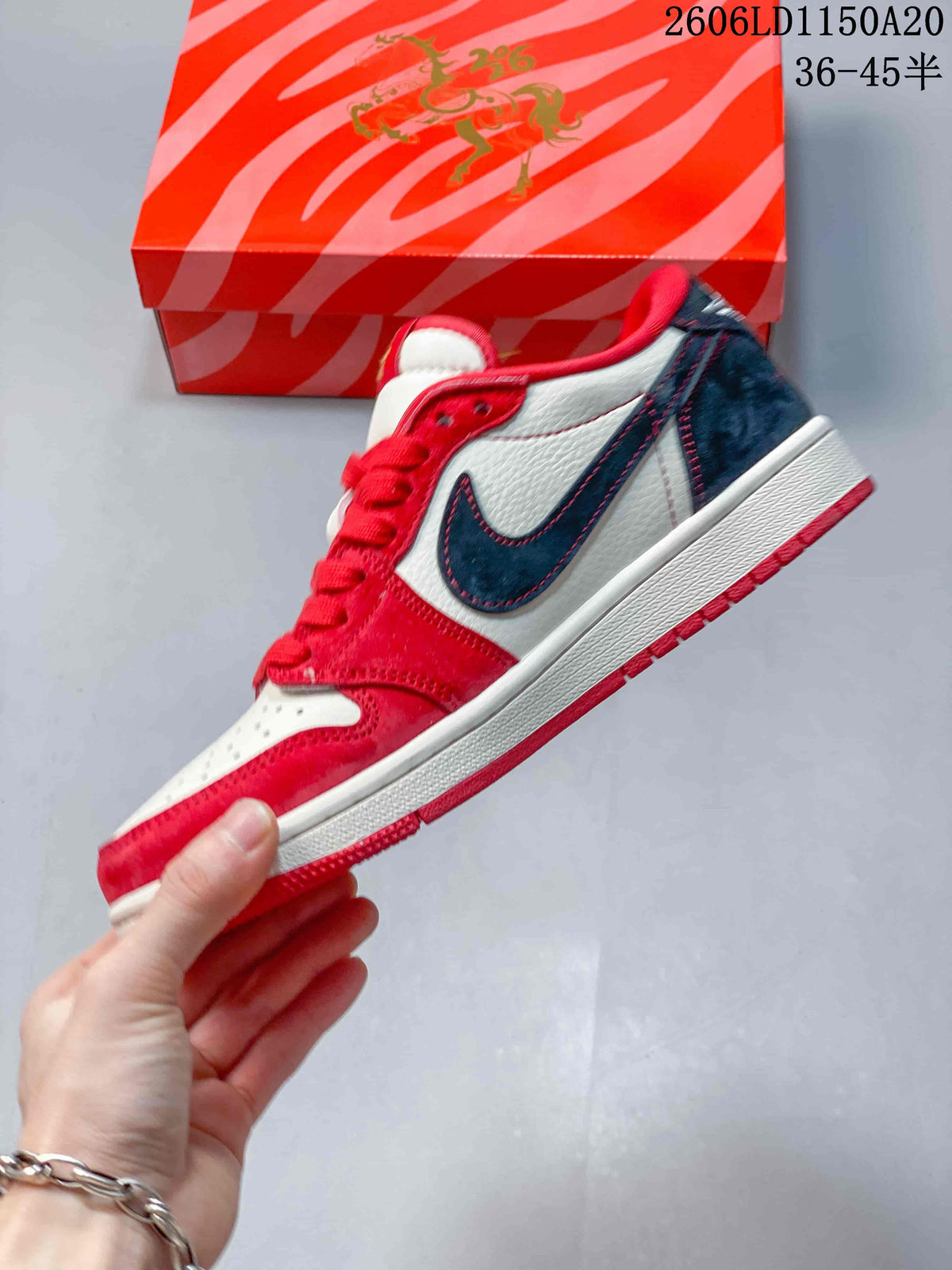 Side view of a red, white, and navy low-top sneaker with a contrasting swoosh