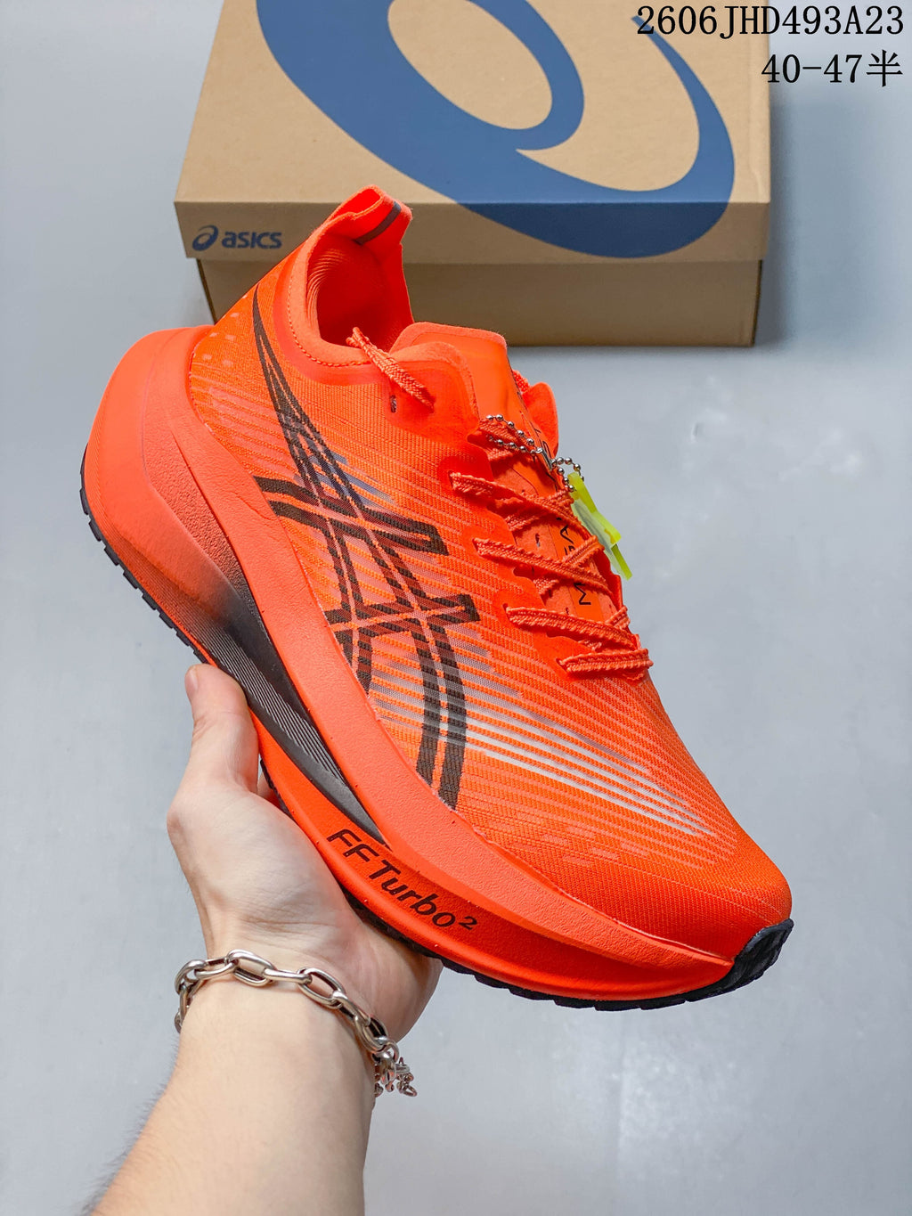 Side view of an orange ASICS running shoe with FF TURBO 2 text