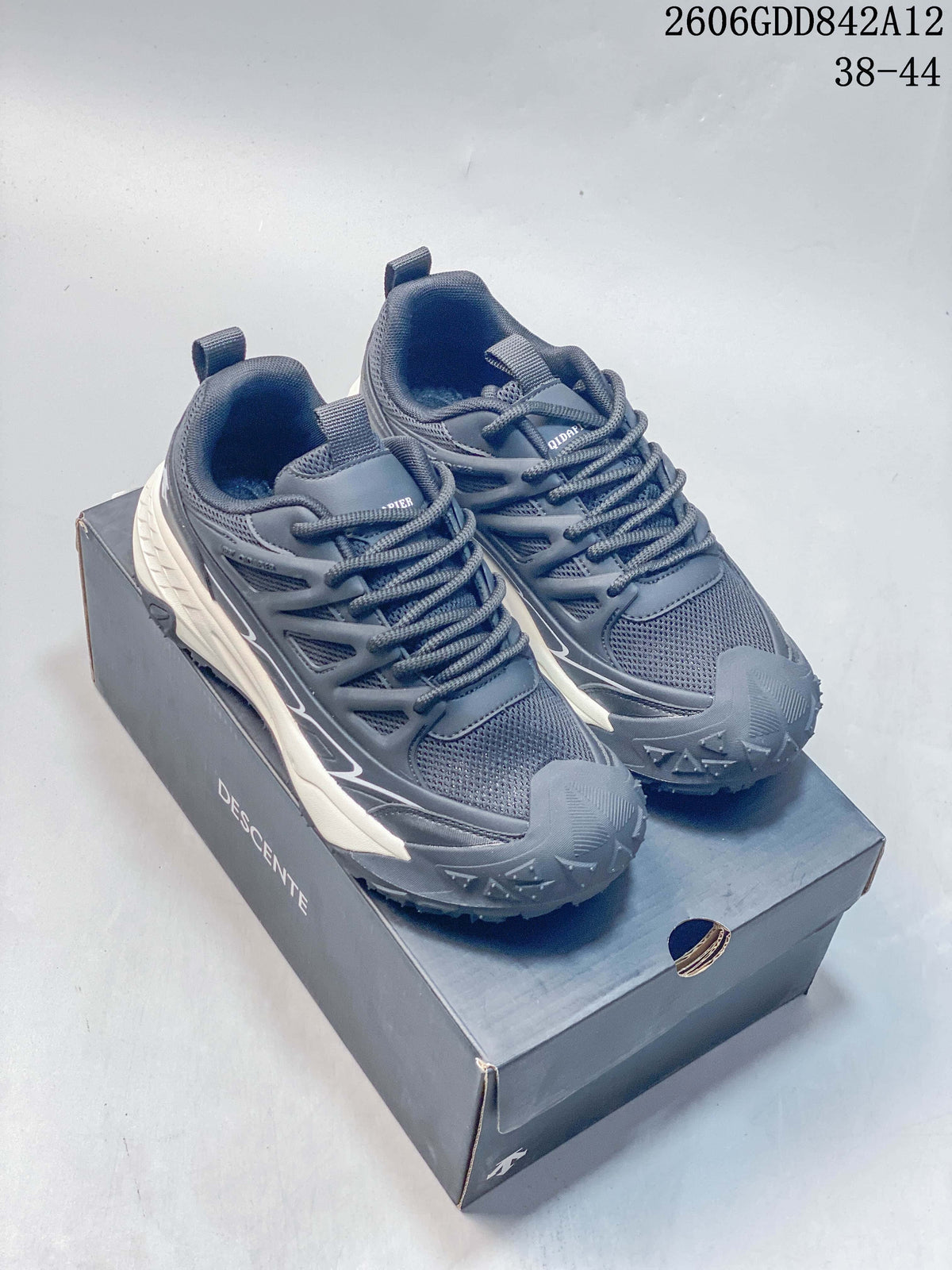 Pair of gray DESCENTE running sneakers on a branded shoe box; style code 2606GDD842A12 and size range 38–44 appear in the image.