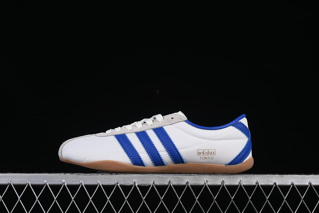 Side view of the white adidas Tokyo sneaker with blue stripes
