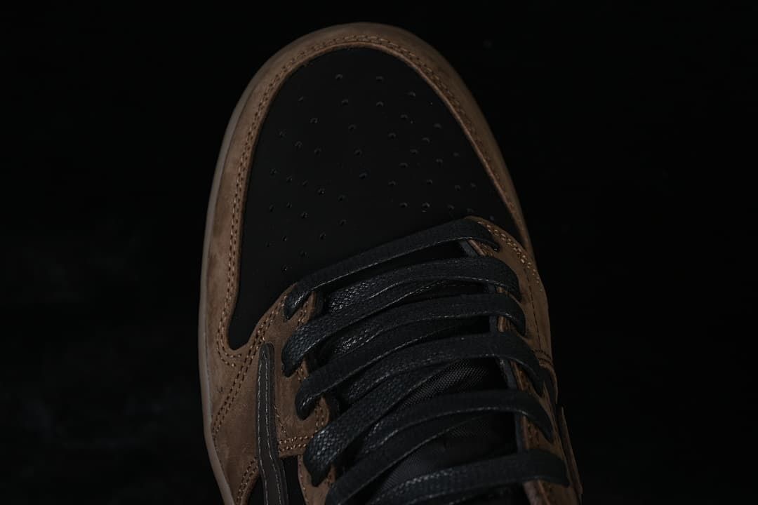 Top view of perforated black toe box, brown overlays, and black laces