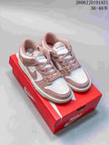 Pair of pink and white Nike Dunk Low SB-style sneakers viewed from above on a red shoe box.