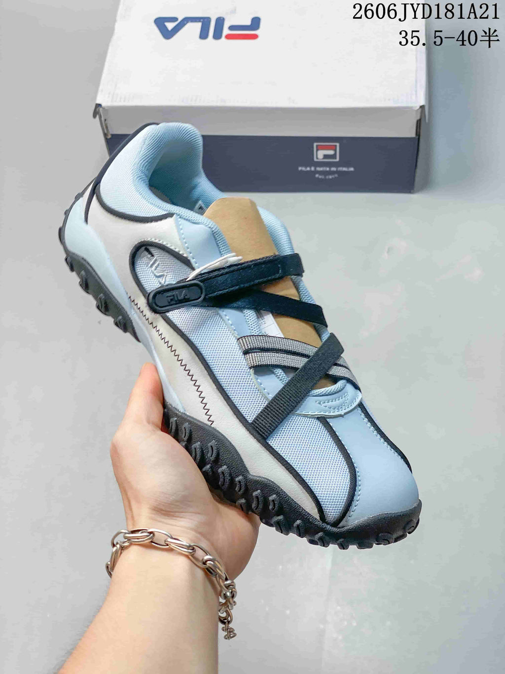 Light blue and white FILA Pebble Sandal shoe with crossed straps and textured outsole