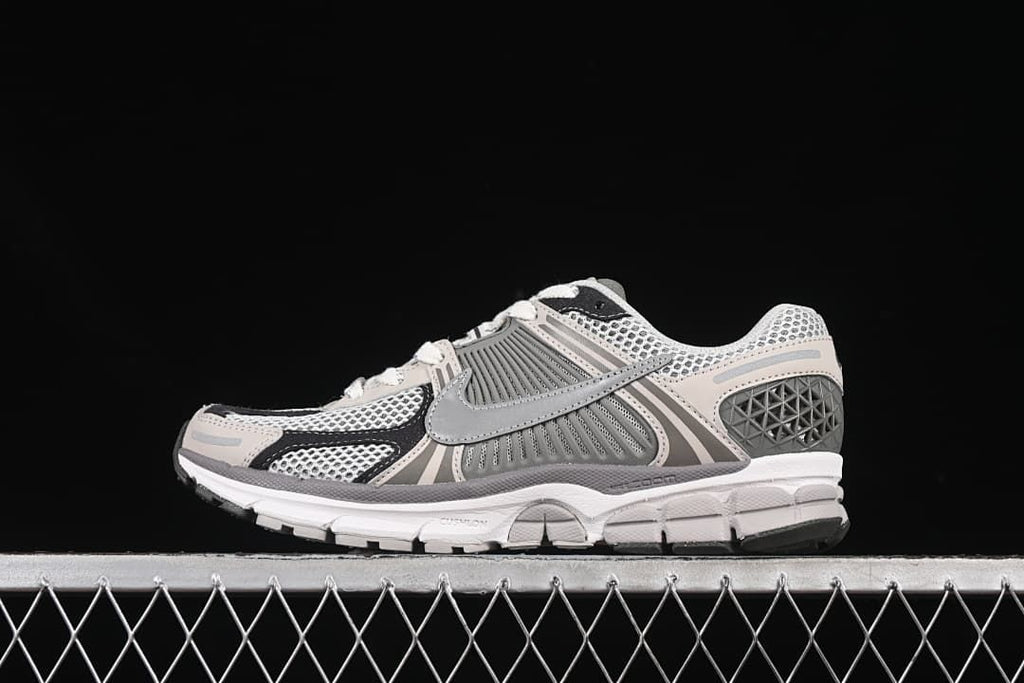 Side profile of the Nike Zoom Vomero 5 SP sneaker in grey, black and off-white.