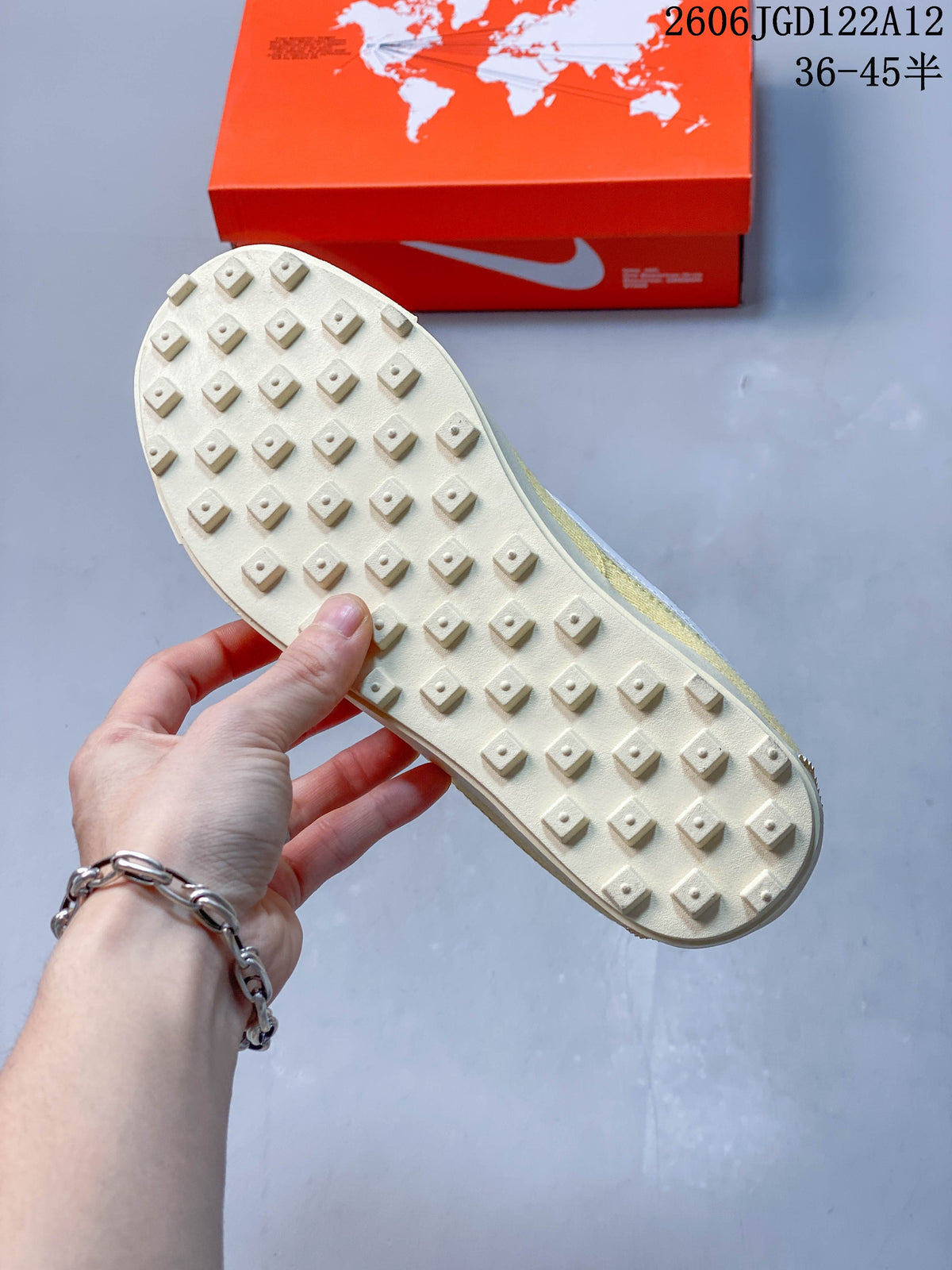 Underside of a Nike Astro Grabber sneaker showing its off-white sole and raised tread.