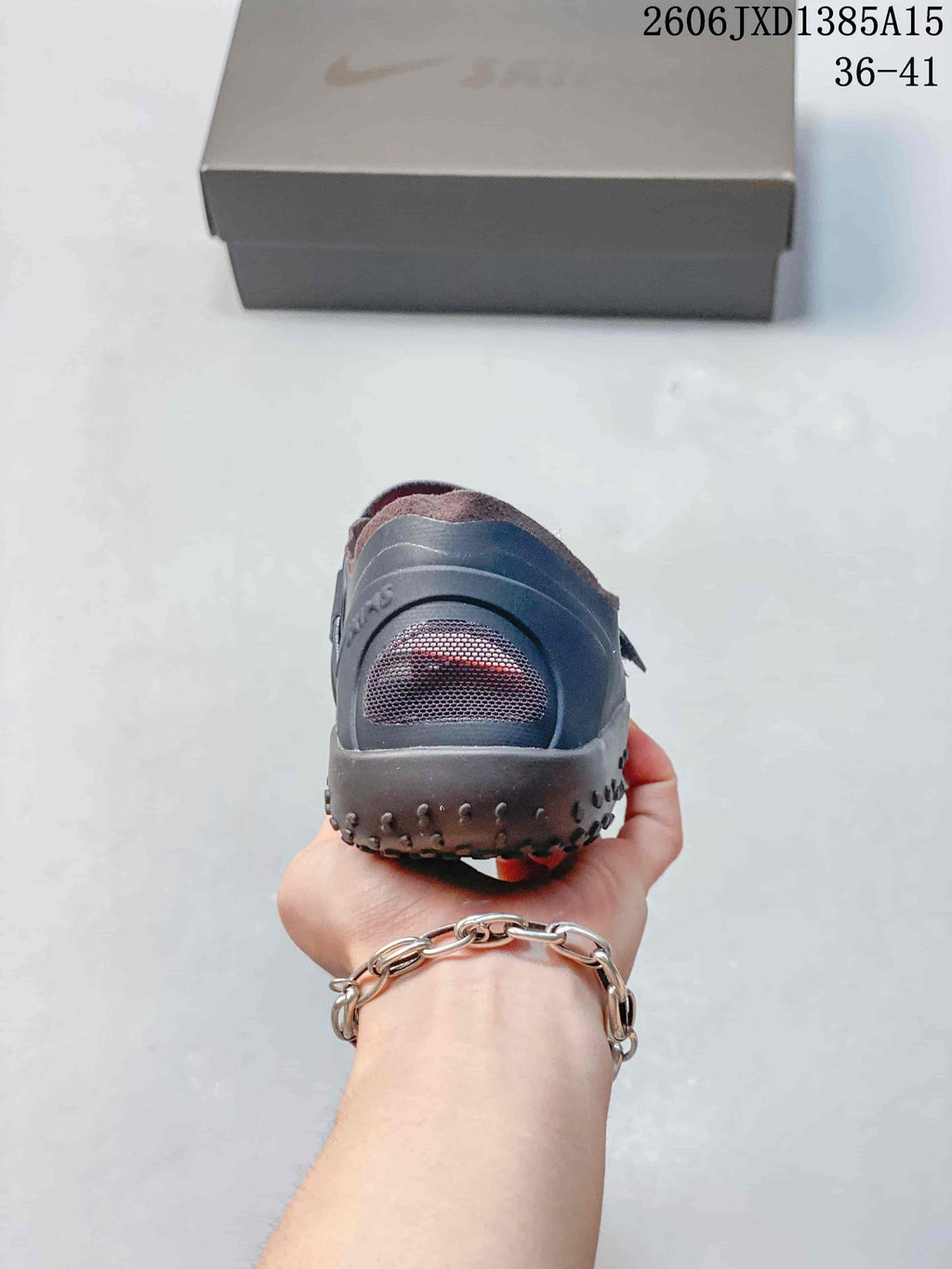Rear view of a dark gray Nike Air Rift shoe showing mesh heel panels and textured sole.