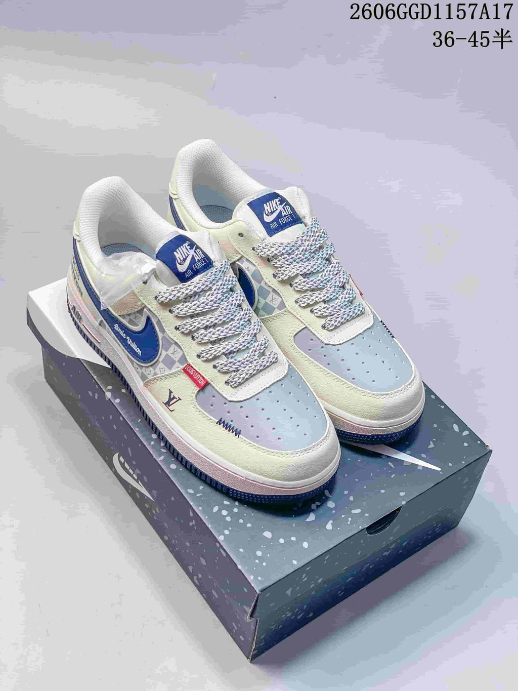 Pair of cream, gray, and blue Nike Air Force 1-style sneakers on a shoe box