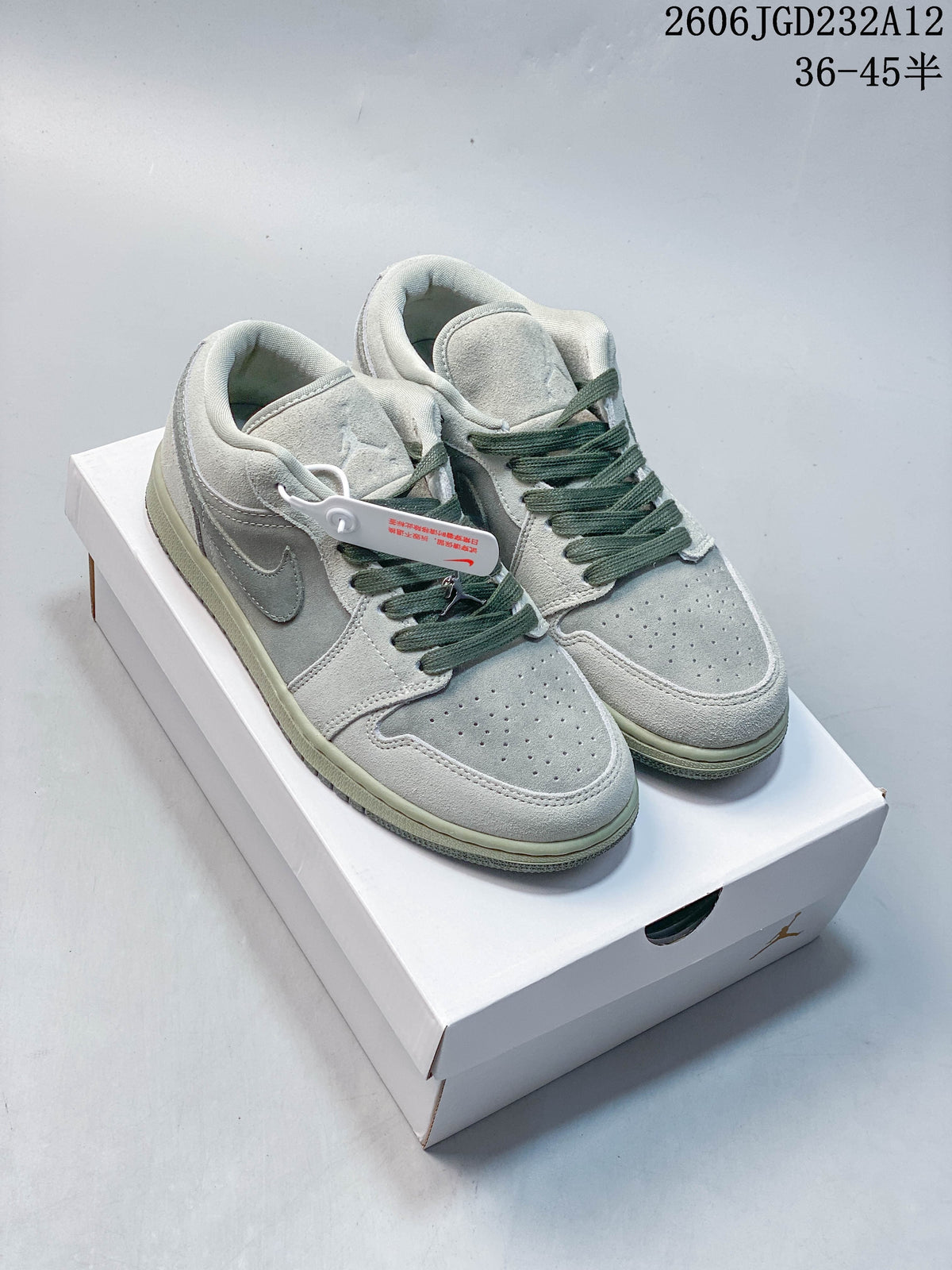Pair of light gray low-top sneakers with muted green laces, shown on a box