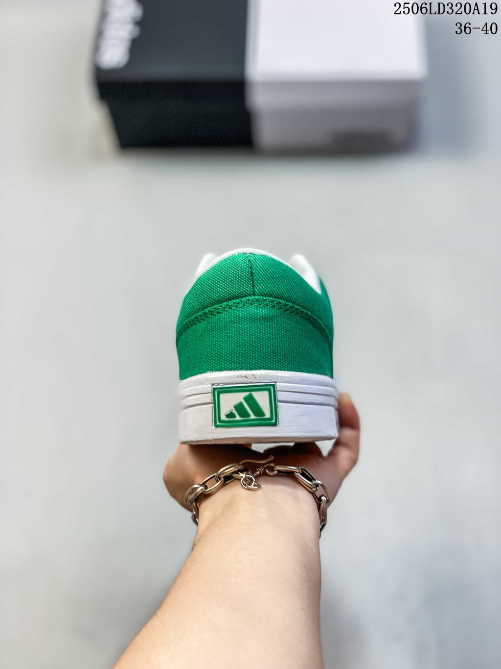 Rear view of the green sneaker with a white sole and heel logo detail