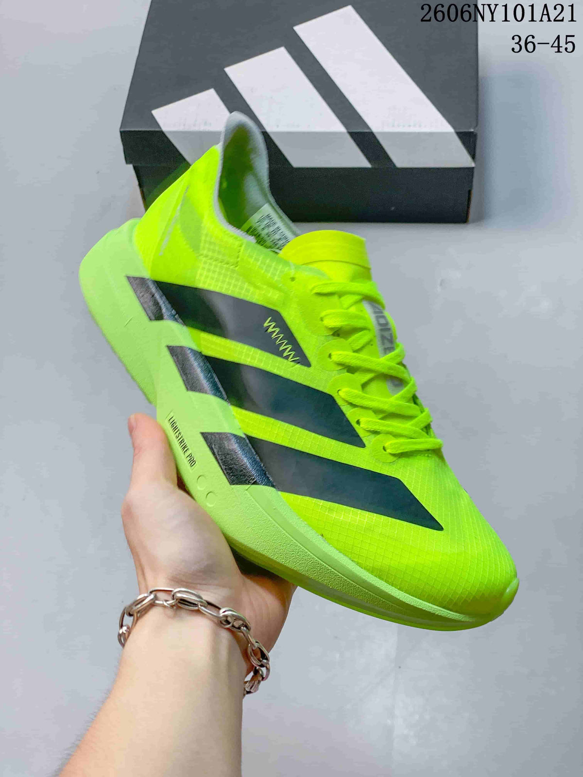 Side profile of the neon yellow Adidas shoe with dark stripes and style code 2606NY101A21 visible in the image overlay.