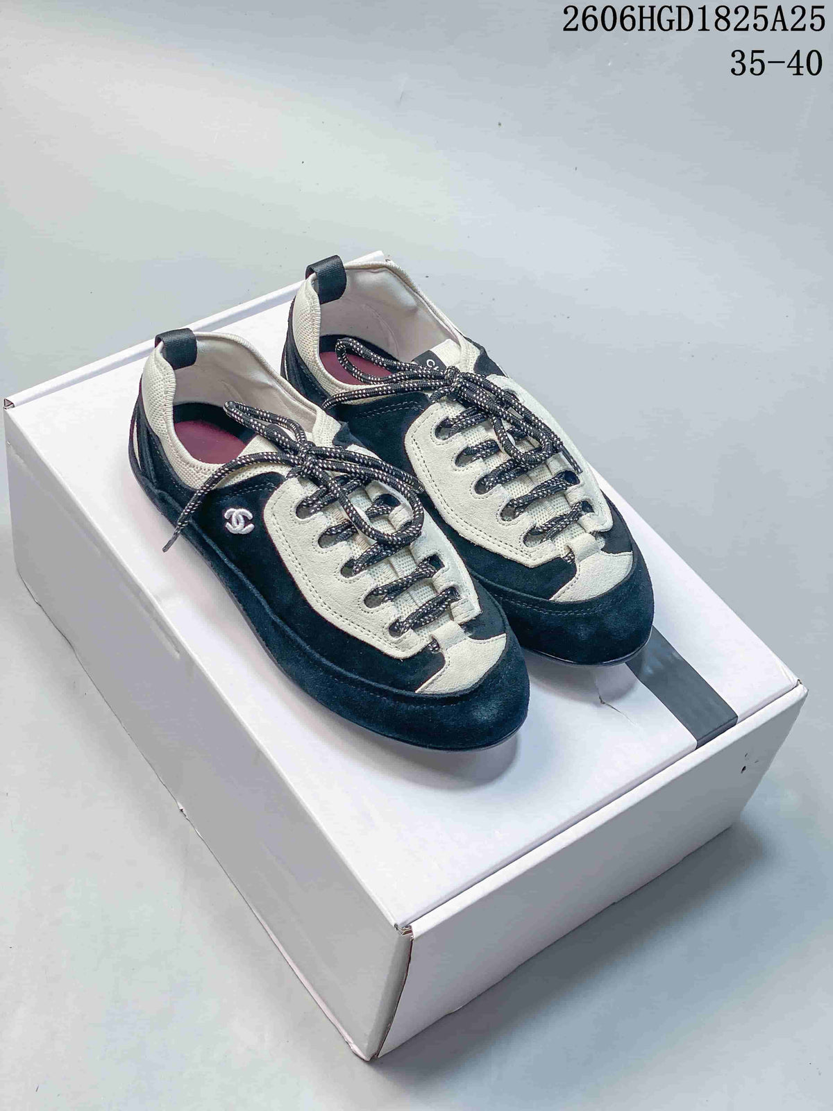 Pair of black and ivory lace-up trainers shown from above.