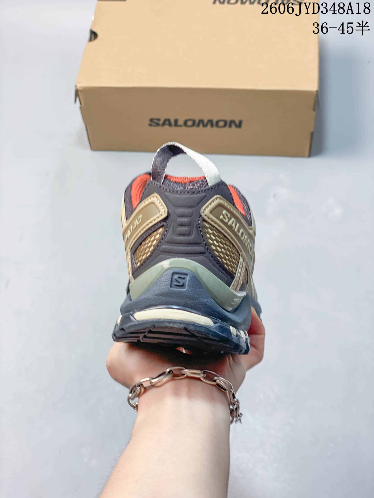 Rear view of the Salomon XT-3D shoe showing the heel structure and orange lining; image also displays a size range.