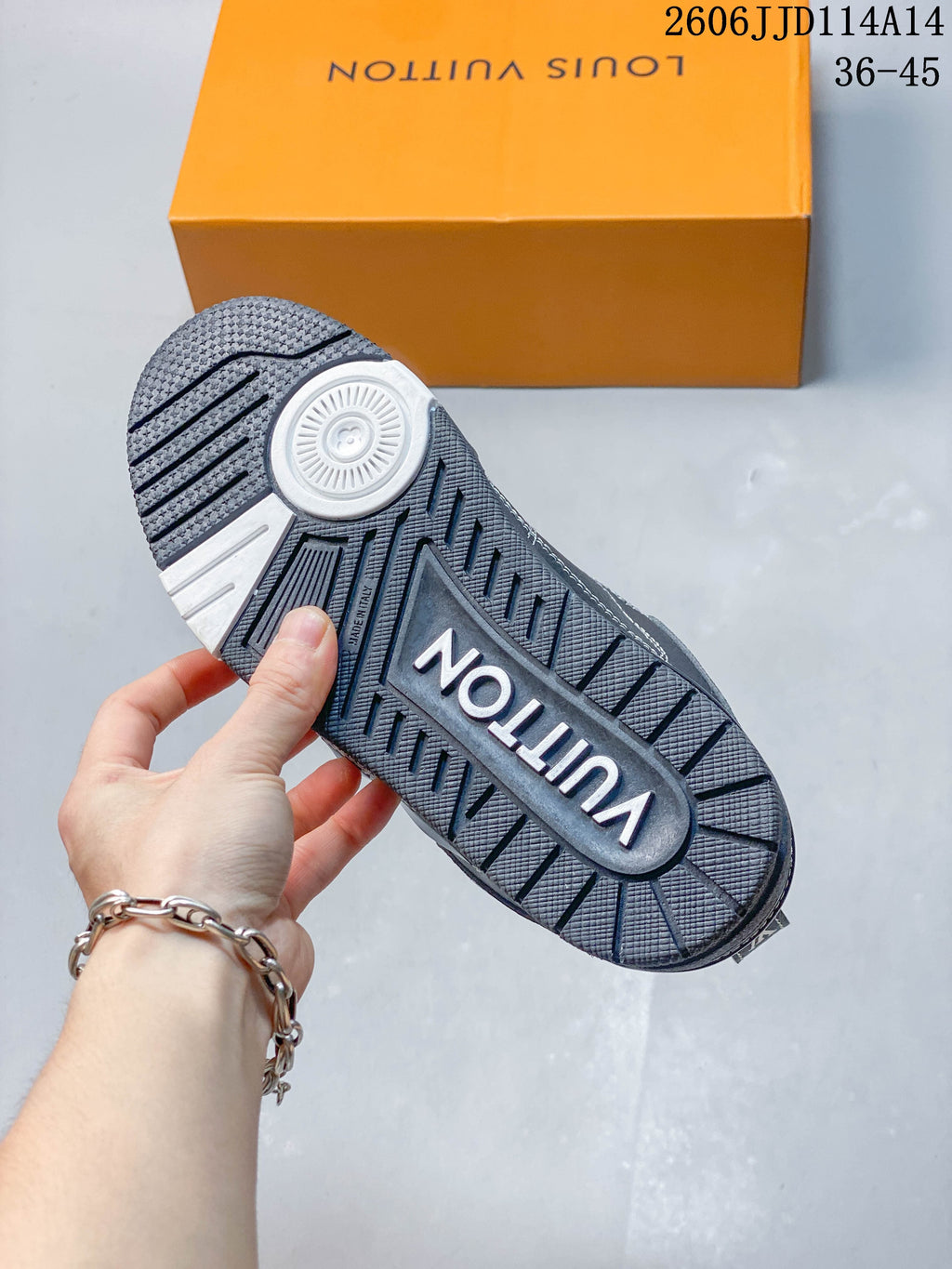 Textured outsole of the charcoal sneaker with a central brand marking