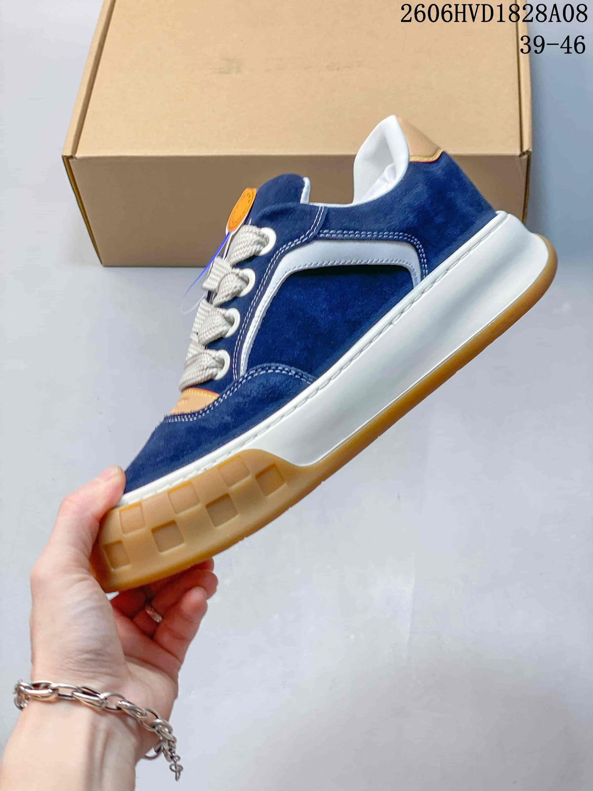 Side view of a blue low-top sneaker with white accents and a gum-colored outsole