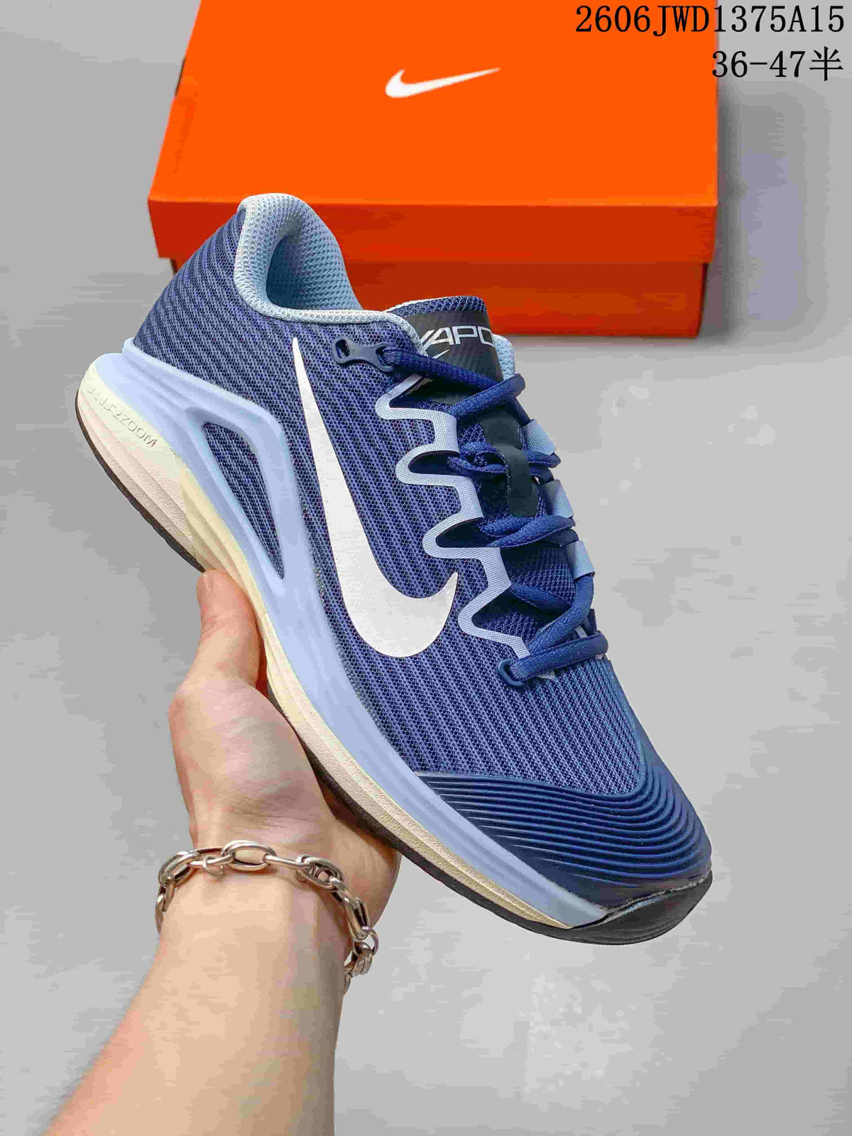 Close side view of a blue and white Nike Vapor 12 shoe