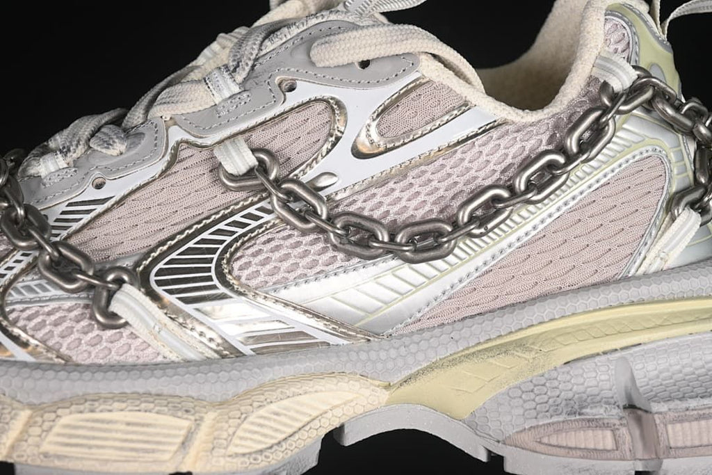 Close-up of the layered side panels, mesh-like sections, and metal-tone chain.