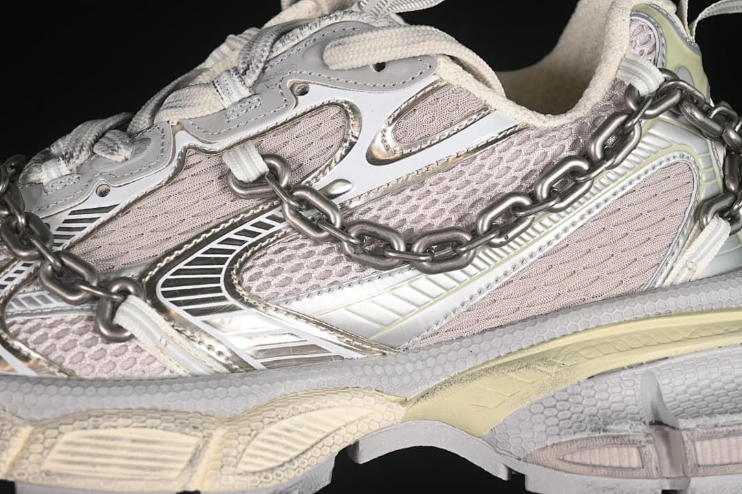 Close-up of the layered side panels, mesh-like sections, and metal-tone chain.