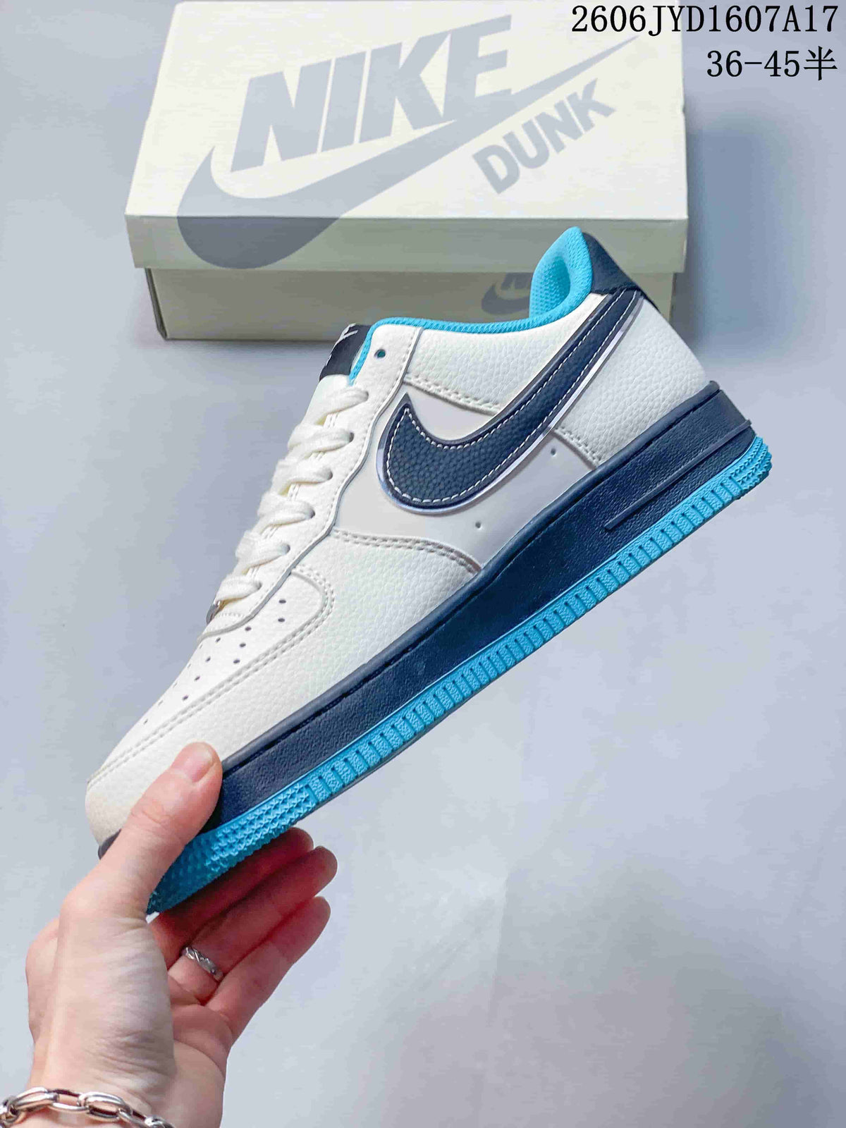 Side view of the white low-top sneaker with navy Swoosh and turquoise outsole