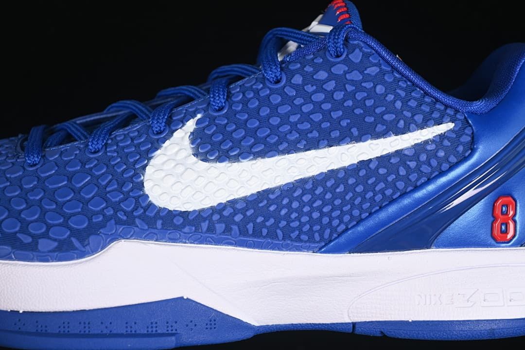 Close-up of the textured blue upper, white Swoosh, and red number 8