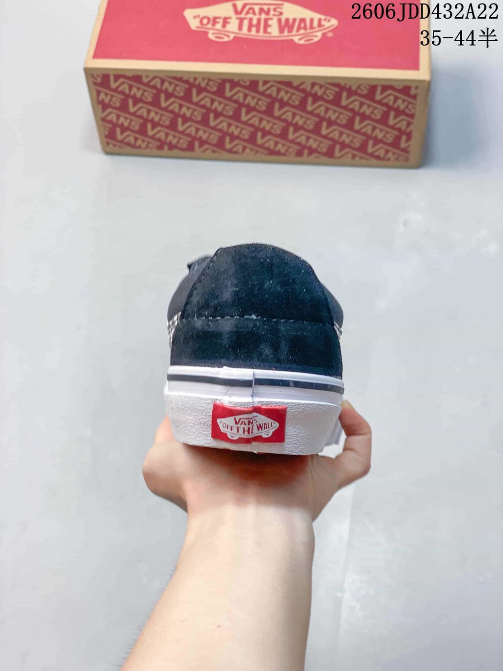Rear view of a black Vans low-top sneaker with a white sole