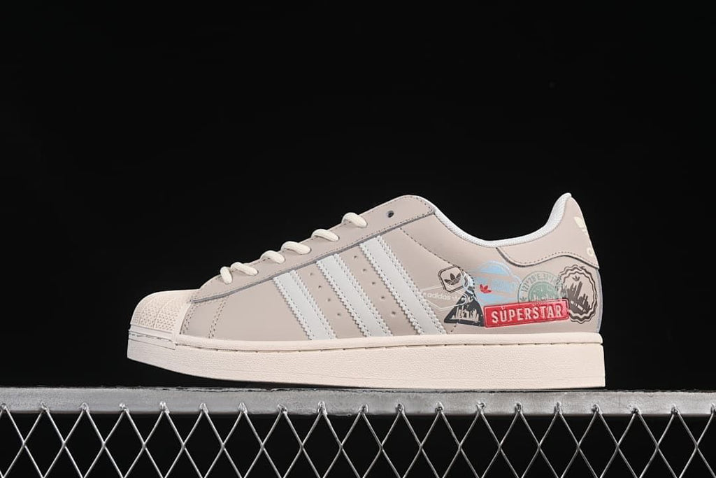 Side profile of the Superstar II with beige upper, white stripes and colorful graphics.