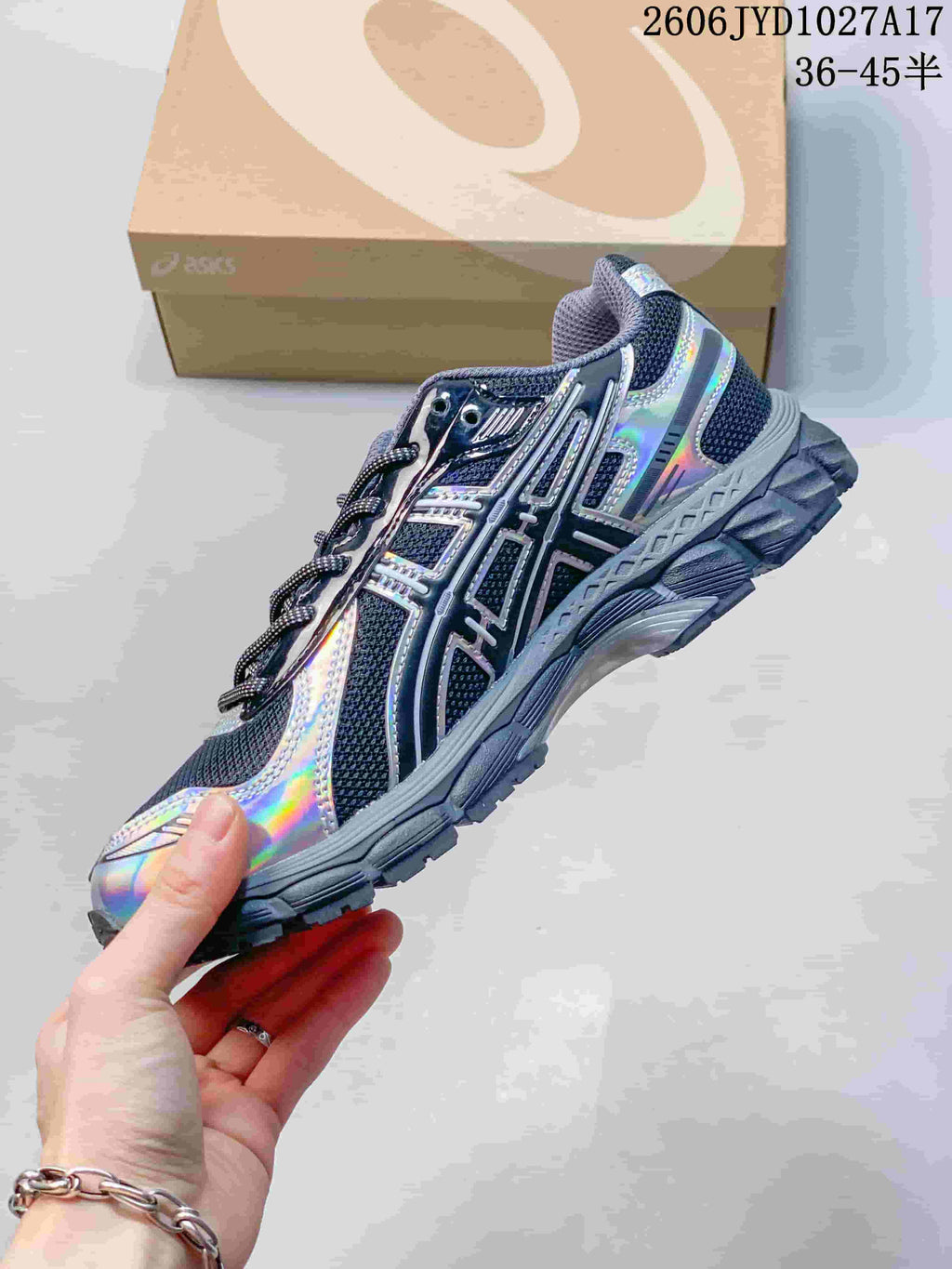 Side view of a dark gray Kith x ASICS GEL-KAYANO 12.1 sneaker with iridescent panels