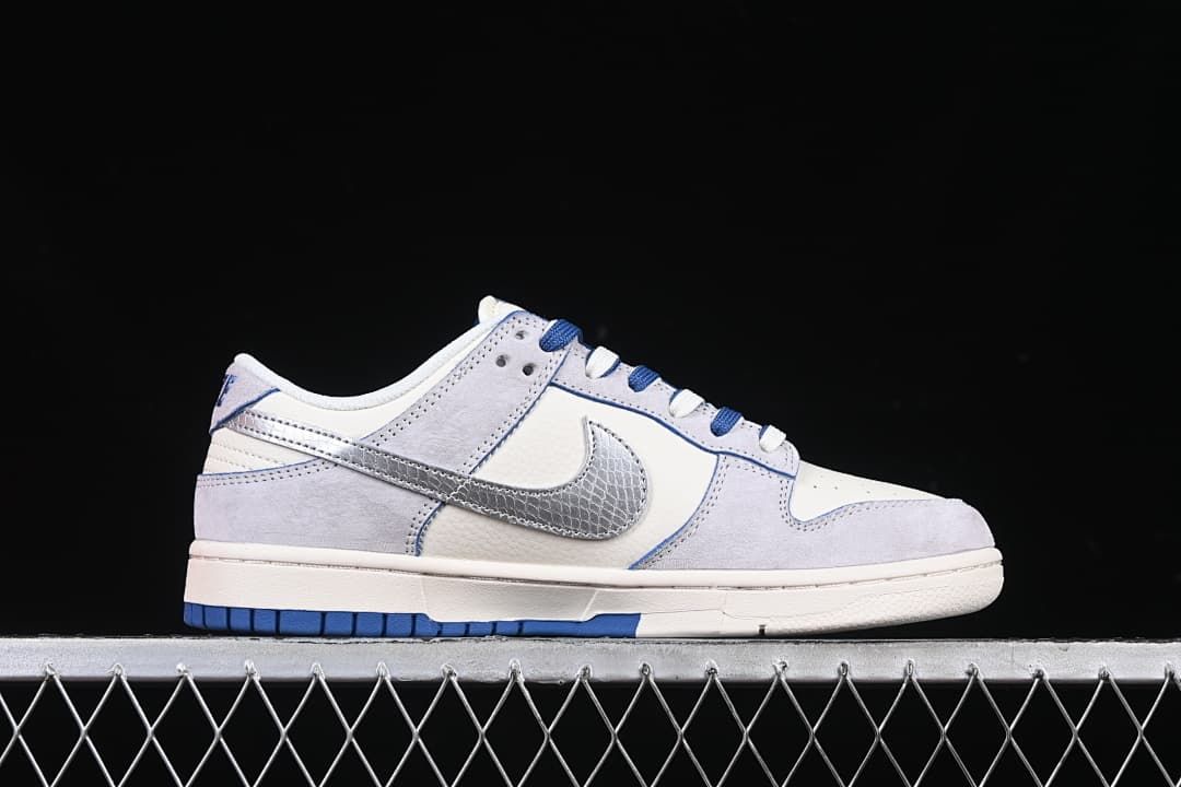 Side profile of the low-top sneaker with pale gray overlays and a metallic silver patterned Swoosh