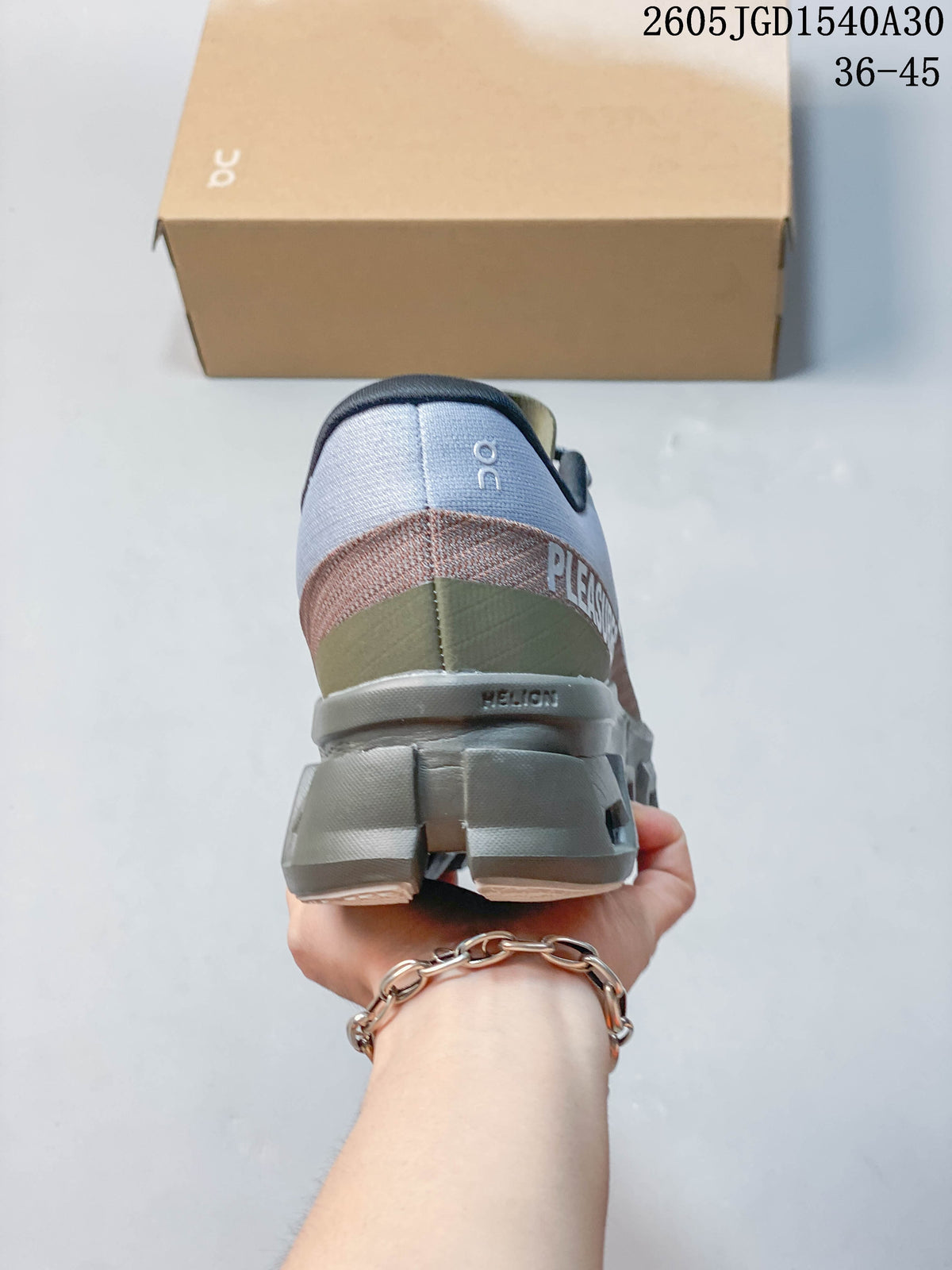 Rear view of a gray sneaker showing olive and muted rose heel accents