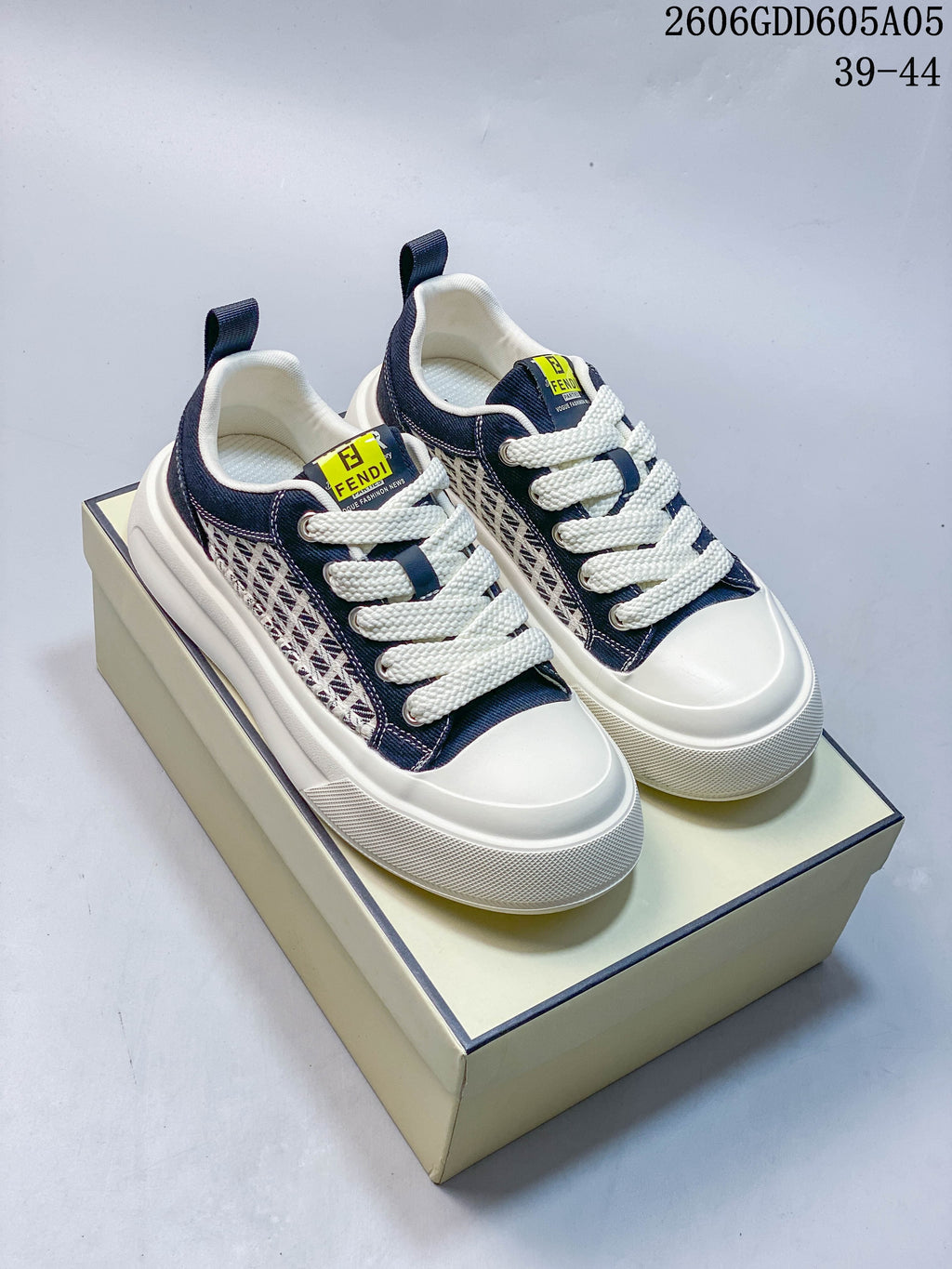 Navy and ivory low-top lace-up sneakers with patterned side panels and thick textured soles